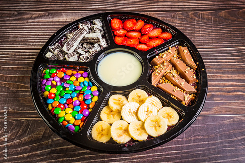 Acai frozen with banana, granola, chocolate and candies for share. A roulette for share.