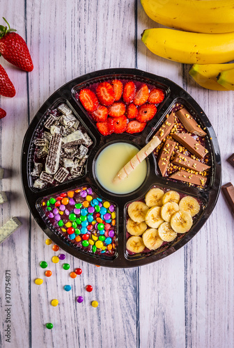 Acai frozen with banana, granola, chocolate and candies for share. A roulette for share.