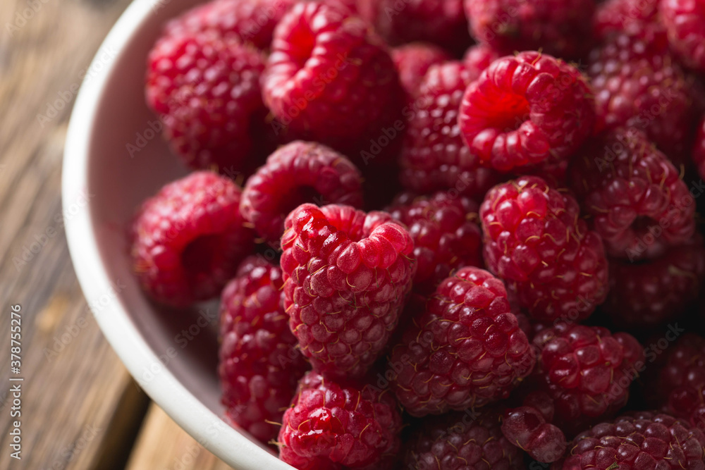 Fresh raspberries in a bowl on a wooden table Fresh raspberries in a bowl on a wooden table