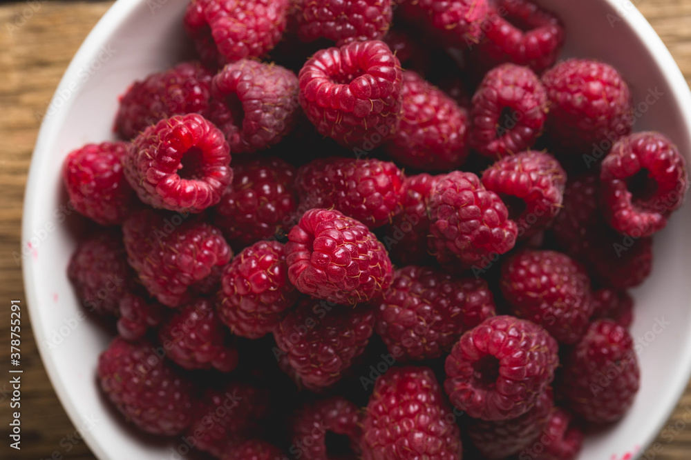 Fresh raspberries in a bowl on a wooden table Fresh raspberries in a bowl on a wooden table