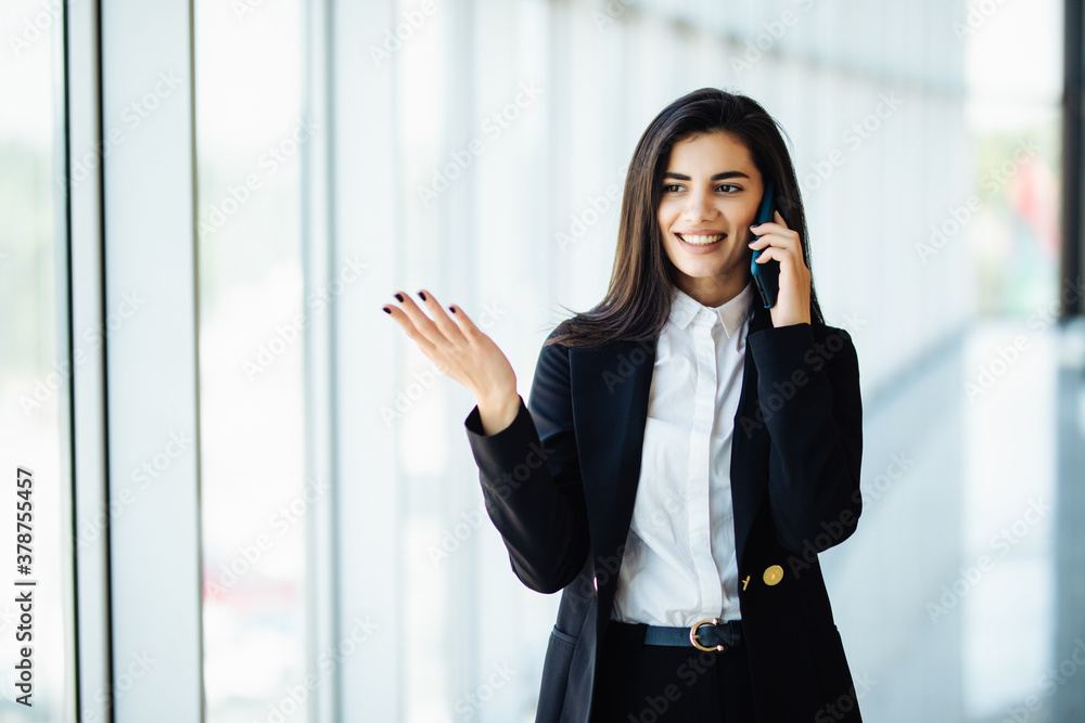 Smart business woman talking by mobile phone in office Smart business woman talking by mobile phone in office