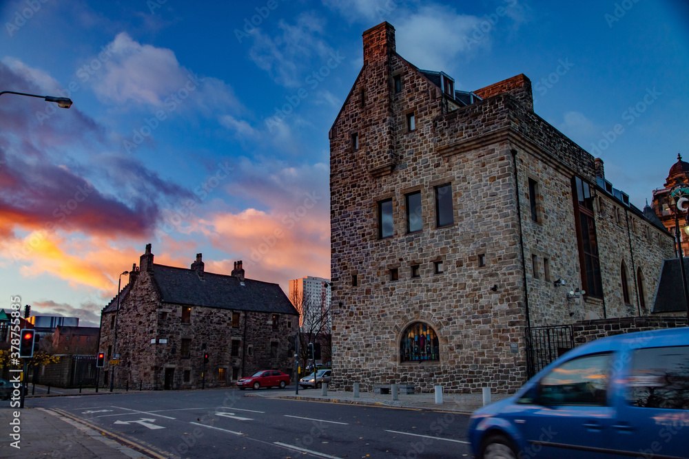 Glasgow / Scotland - Nov 13, 2013: Evening cityscape. Old brick houses on Cathedral Square on sunset. Blue, orange, red clouds.