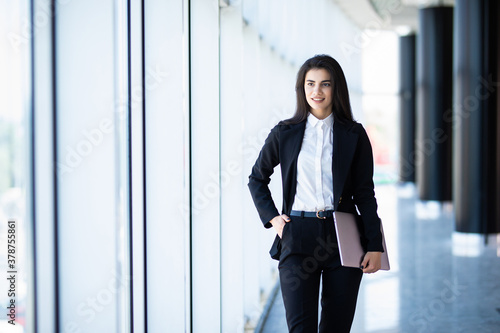 Young businesswoman with laptop in office hall with panoramic windows Free Download Young businesswoman with laptop in office hall with panoramic windows - GFXLoad