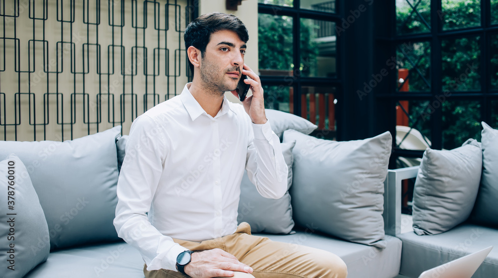 Confident businessman speaking on smartphone in cafe Confident businessman speaking on smartphone in cafe