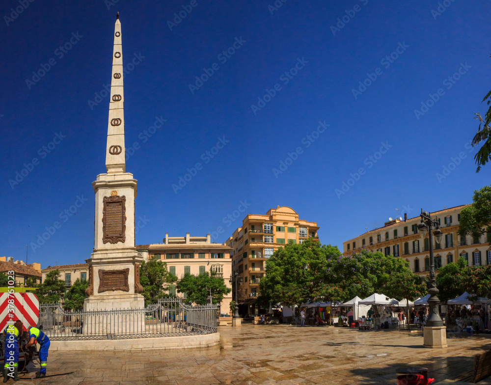 Malaga, Spain: Plaza de la Merced in the old town, with its obelisk memorial, the 'Obelisco de Torrijos', on a cloudless day in summer.