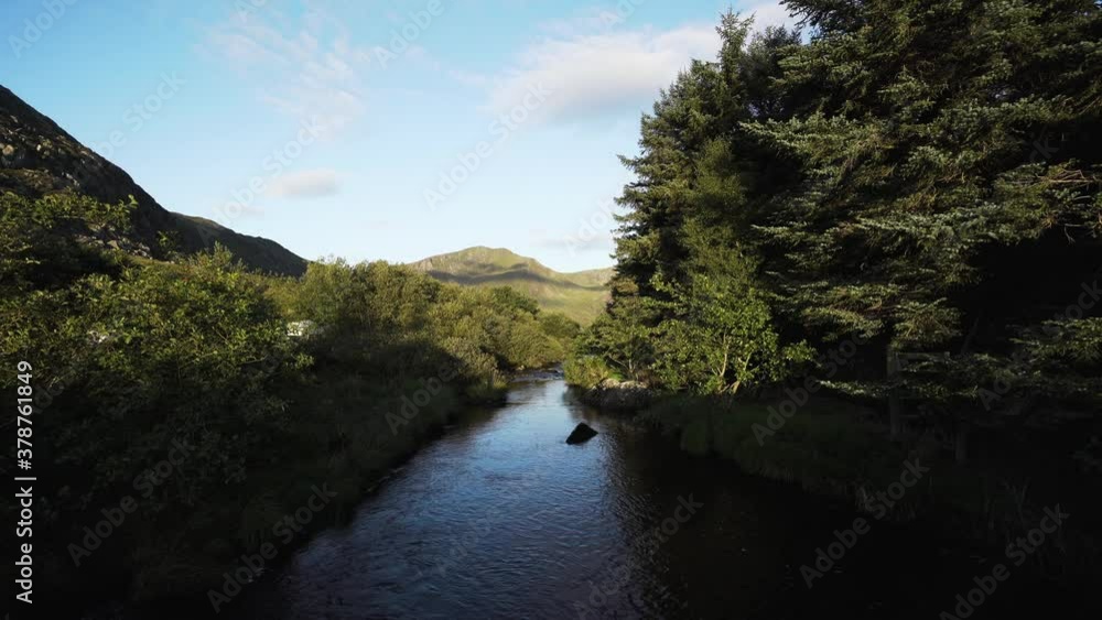 A mountain stream flowing through woodland in Snowdonia UK A mountain stream flowing through woodland in Snowdonia UK