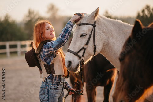 Young woman farmer combing a horse at the ranch. Medium shot.