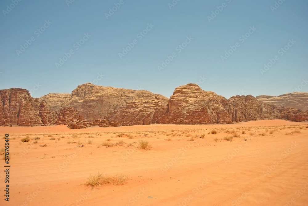 Ancient sandstone rocks and orange sand of the Wadi Rum desert