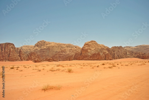 Ancient sandstone rocks and orange sand of the Wadi Rum desert