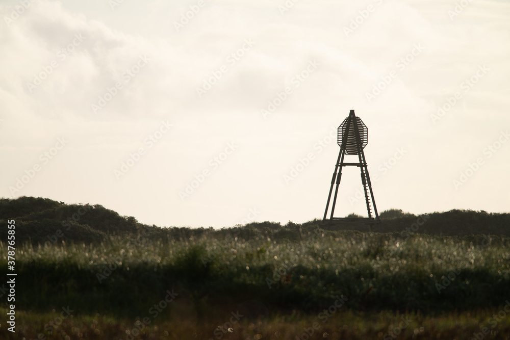 Naklejka premium The beacon on Amelend, A cape or sea cape is a beacon for shipping and is a striking landmark in the landscape. on the beautiful Oerd, protected nature area on Ameland, the Netherlands
