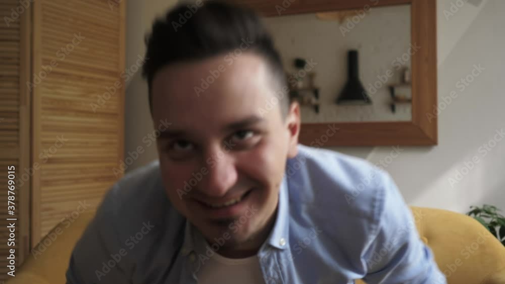 Smiling young adult man vlogger look at camera talk make live video conference Smiling young adult man vlogger look at camera talk make live video conference