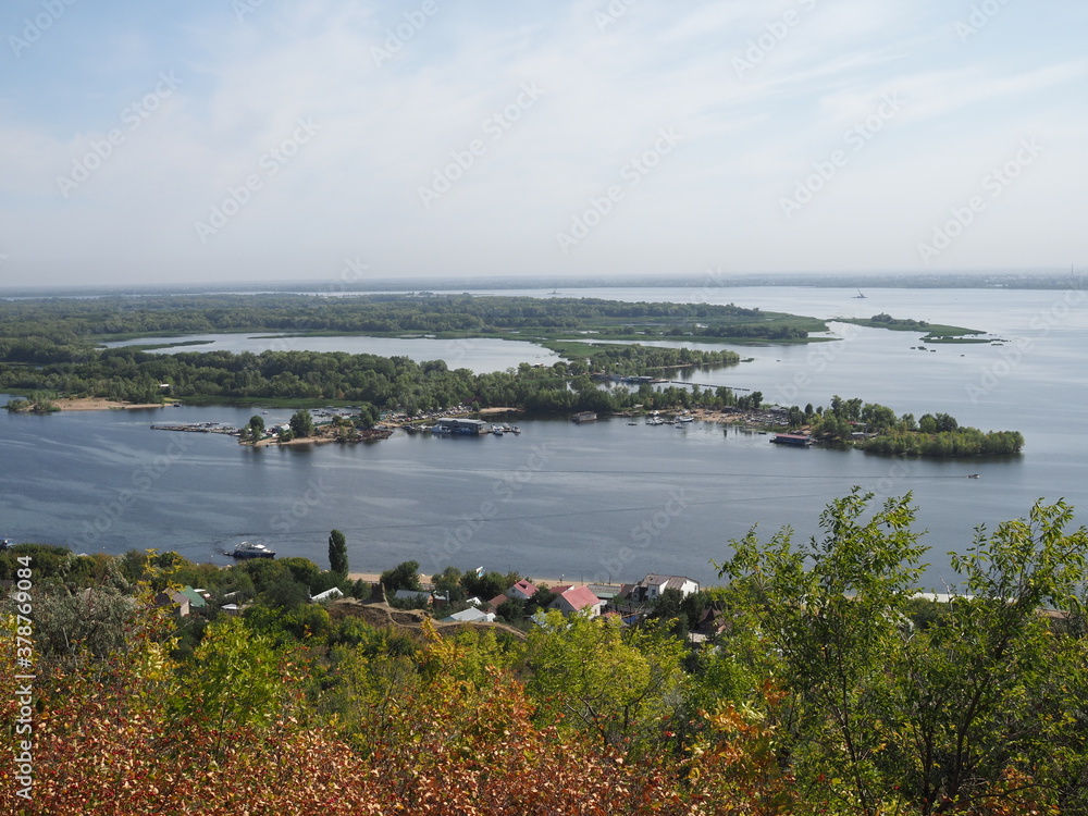 Picturesque panoramic view from the height on the touristic part of the Volga river near Saratov city at summer sunny day.Beautiful natural landscape.Central part of Russia.Europe. Picturesque panoramic view from the height on the touristic part of the Volga river near Saratov city at summer sunny day.Beautiful natural landscape.Central part of Russia.Europe.