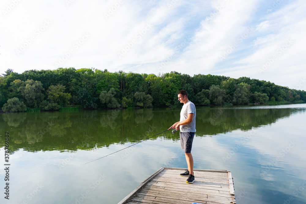 Man fishing on the river. Spinning fishing competition Man fishing on the river. Spinning fishing competition