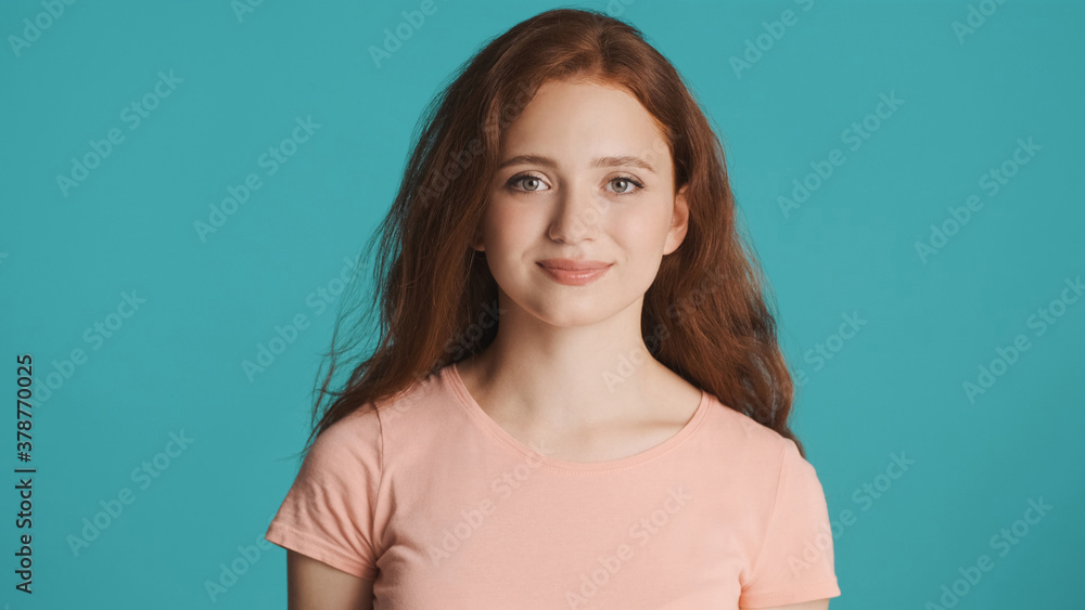 Beautiful smiling girl intently looking in camera over colorful background Beautiful smiling girl intently looking in camera over colorful background