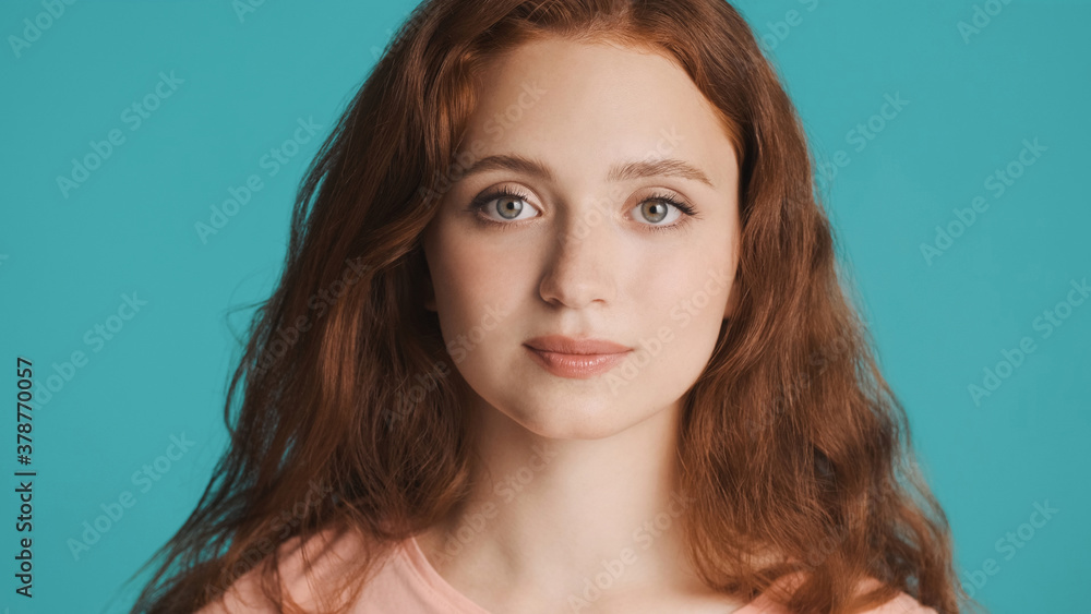 Close up beautiful girl intently looking in camera over colorful background Close up beautiful girl intently looking in camera over colorful background