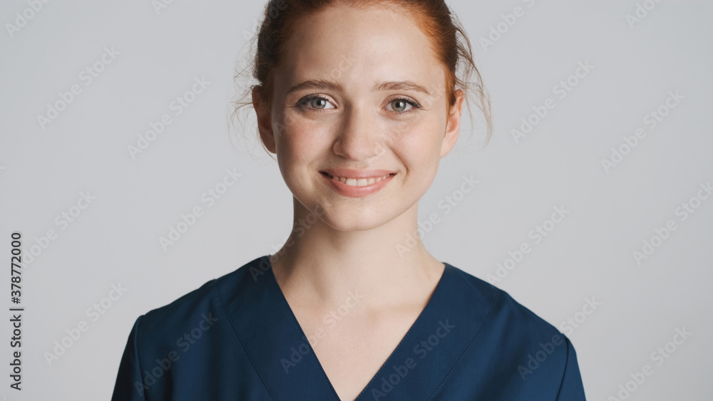 Young beautiful female doctor happily looking in camera over white background Young beautiful female doctor happily looking in camera over white background