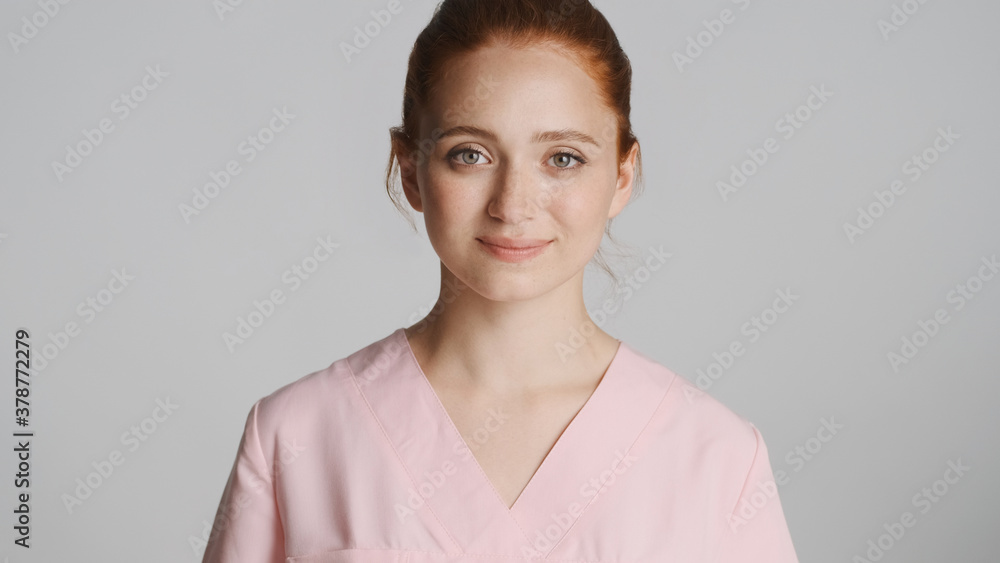 Young nurse in uniform smiling on camera over white background Young nurse in uniform smiling on camera over white background