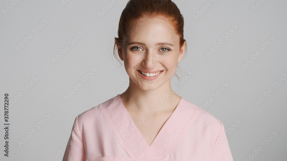 Young beautifu nurse in uniform happily looking in camera over white background Young beautifu nurse in uniform happily looking in camera over white background