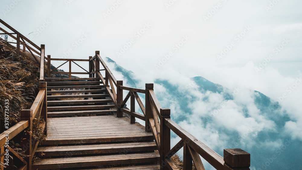 Fototapeta premium Wooden path with view of mountain covered by clouds on Wugong Mountain in Jiangxi, China