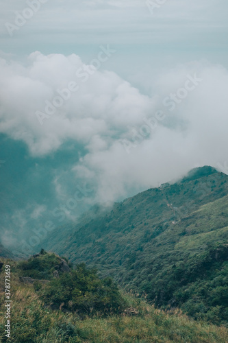 Meadow landscape with mountains covered by clouds on Wugong Mountain in Jiangxi, China © Mark Zhu