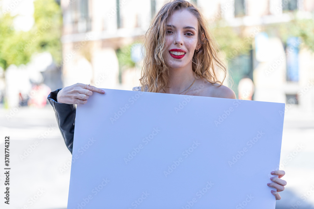 Modelo femenina posando en entorno urbano de Madrid Capital, vestida con ropa urbana posando con cartel en blanco publicitario a rellenar Modelo femenina posando en entorno urbano de Madrid Capital, vestida con ropa urbana posando con cartel en blanco publicitario a rellenar