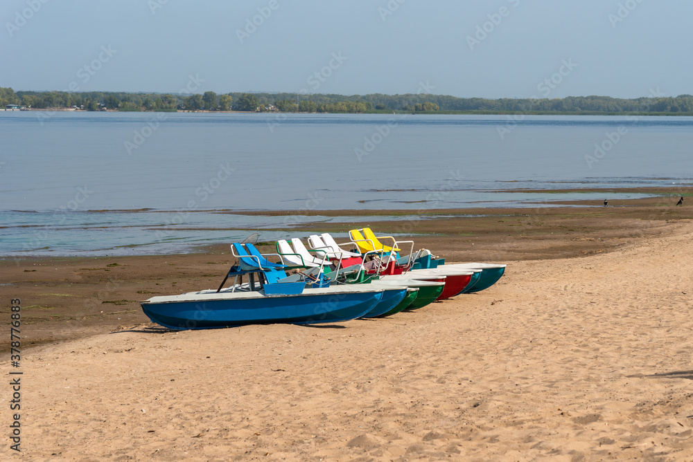 Pedalo rowing catamara stand on an empty sandy beach - pandemic, no people Pedalo rowing catamara stand on an empty sandy beach - pandemic, no people