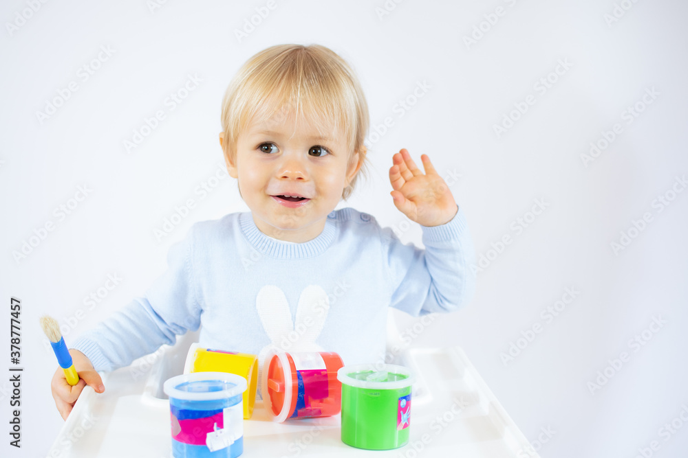 Amazed toddler boy with colorful paints on face isolated on white background Amazed toddler boy with colorful paints on face isolated on white background