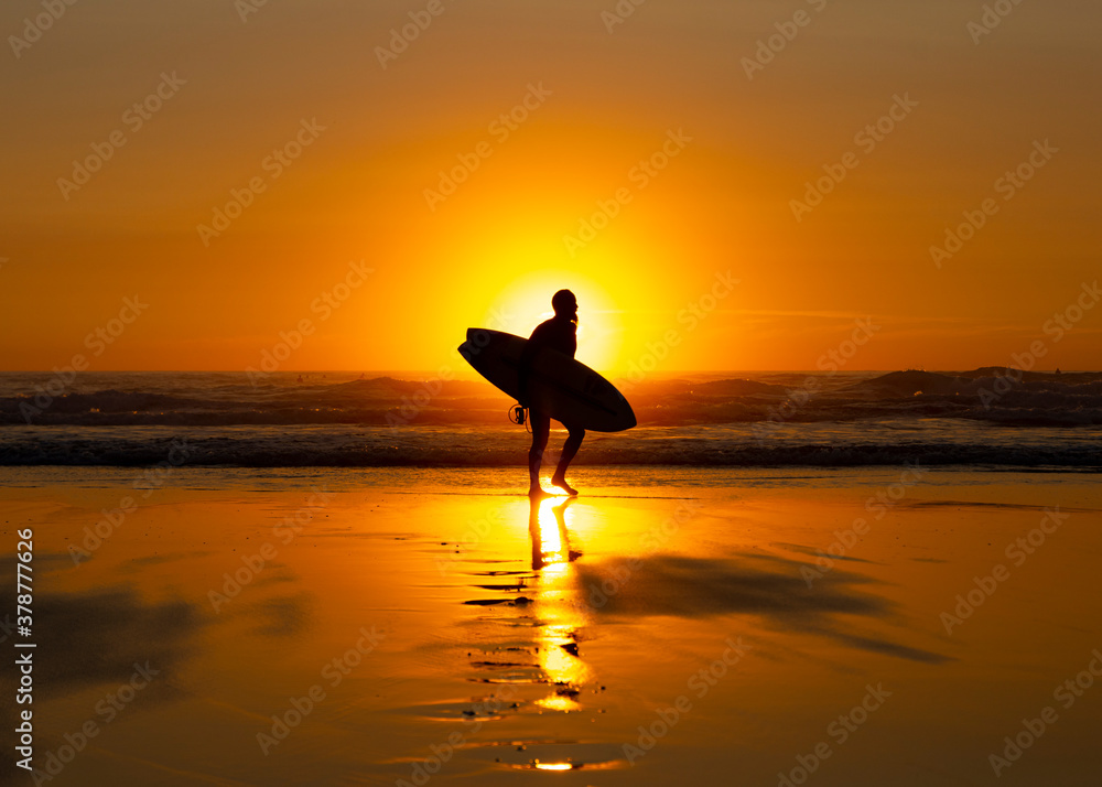 Silhouetted Surfer at Sunset on Widemouth Bay - Bude, Cornwall, England