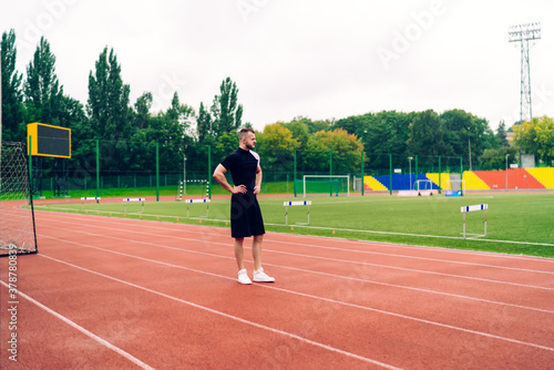 Professional young sportsman preparing for training on stadium