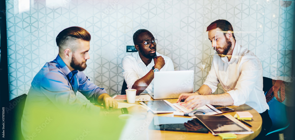 Φωτογραφία Group of diverse male colleagues in formal clothing sitting at office desk with