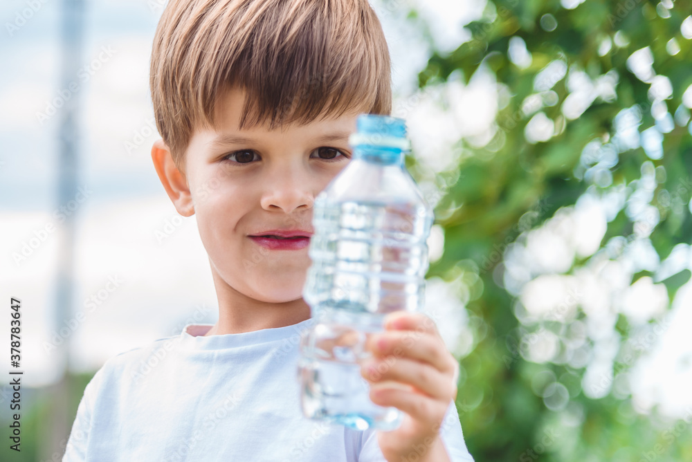 joyful child drinks clear water from a bottle on a sunny day in nature joyful child drinks clear water from a bottle on a sunny day in nature