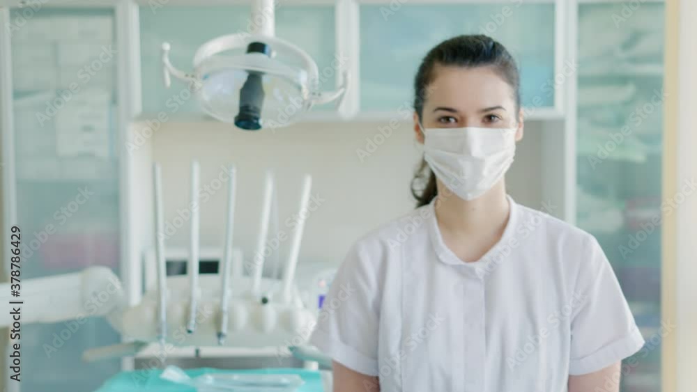 Female dentist in face mask in dentists office Female dentist in face mask in dentists office