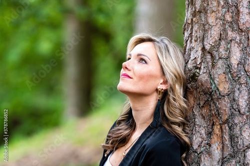 portrait of a beautiful young woman posing near a tree