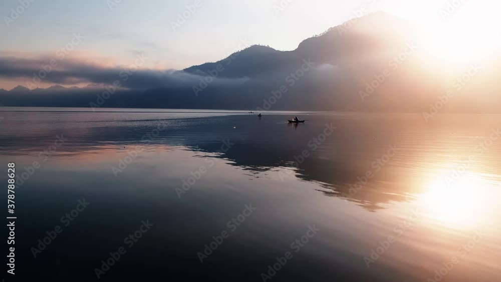 Calm lake in Bali, Indonesia. Fisherman waiting for the days catch beside the mountains. Calm lake in Bali, Indonesia. Fisherman waiting for the days catch beside the mountains.