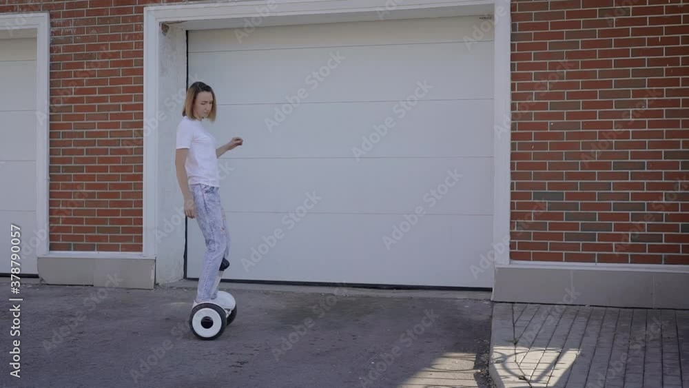 A slender young girl rides a gyro scooter along a city street. Modern electric transport. A slender young girl rides a gyro scooter along a city street. Modern electric transport.
