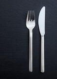 Cutlery isolated on black background, vertical top view