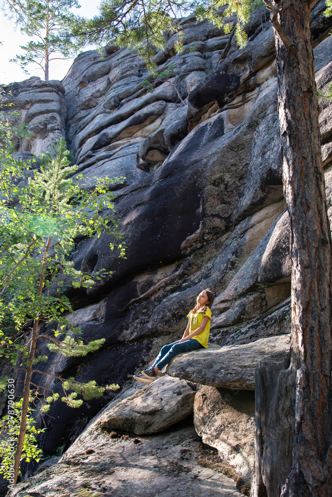 Girl sitting on the rock on the background of moutain in the summer. Girl sitting on the rock on the background of moutain in the summer.