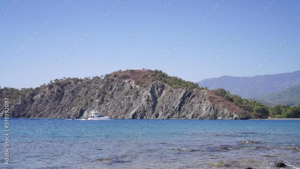Kemer. Turkey. September 9, 2020; White yacht sails on the sea along the mountainous coastline Kemer. Turkey. September 9, 2020; White yacht sails on the sea along the mountainous coastline