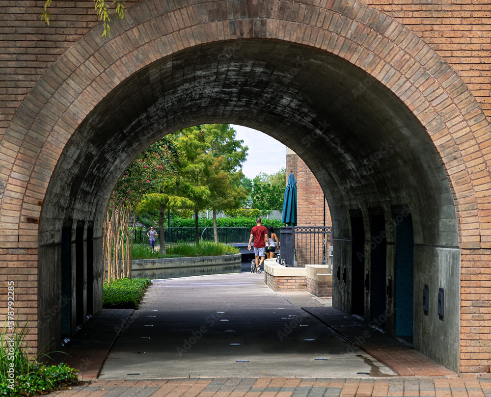walkway through an arched tunnel next to the Waterway in the Woodlands, TX.