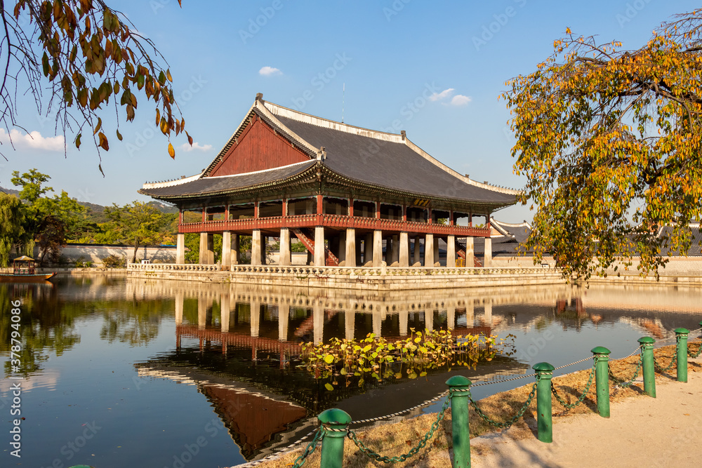 A Korean pavilion reflecting on a lake at Gyeongbokgung Palace on an autumn day