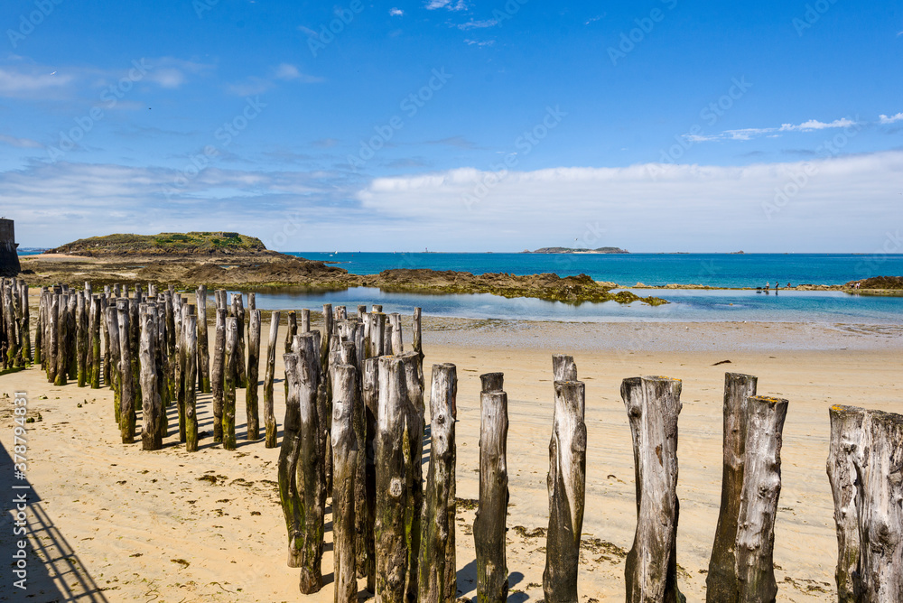 Wooden Poles on the beach at low tide in Saint Malo, Brittany, France Wooden Poles on the beach at low tide in Saint Malo, Brittany, France