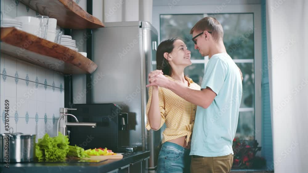 Happy loving couple dancing romantic dance on date in kitchen Happy loving couple dancing romantic dance on date in kitchen