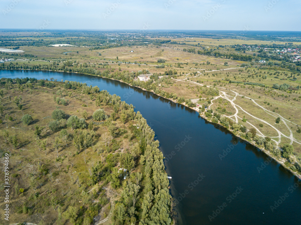 Aerial drone view. The bend of a wide river among green meadows. Sunny summer day.