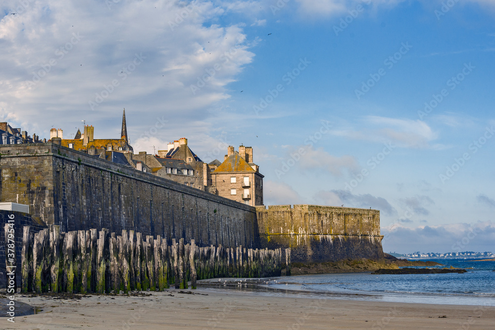 rampart and wooden poles on the beach at low tide in Saint Malo, Brittany, France rampart and wooden poles on the beach at low tide in Saint Malo, Brittany, France