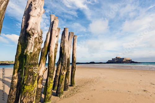 fort national and wooden Poles on the beach at low tide in Saint Malo, Brittany, France