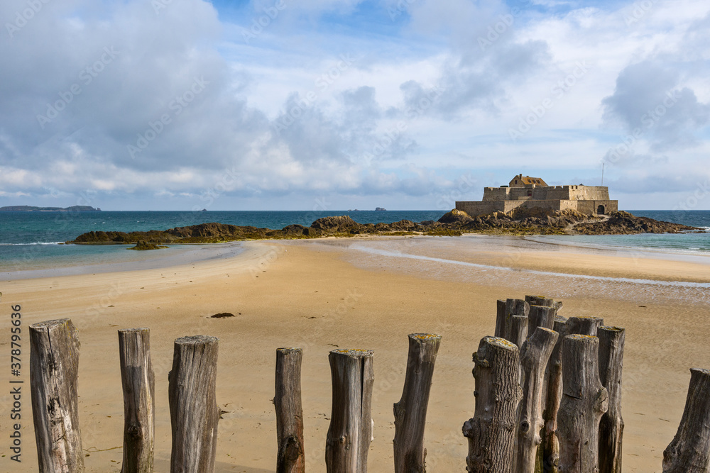 fort national and wooden poles on the beach at low tide in Saint Malo, Brittany, France