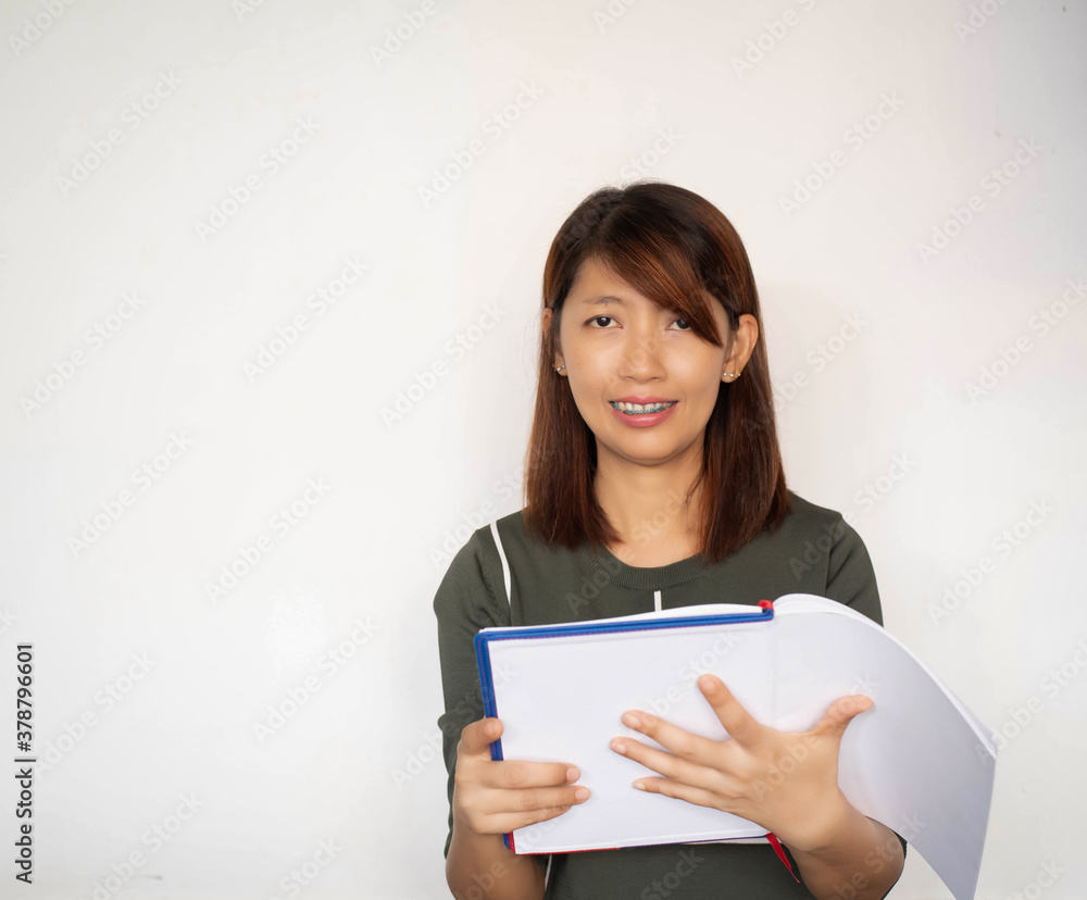 Lady wearing braces,holding book in hand,looking straight and smile,with happy feeling,model posing Lady wearing braces,holding book in hand,looking straight and smile,with happy feeling,model posing