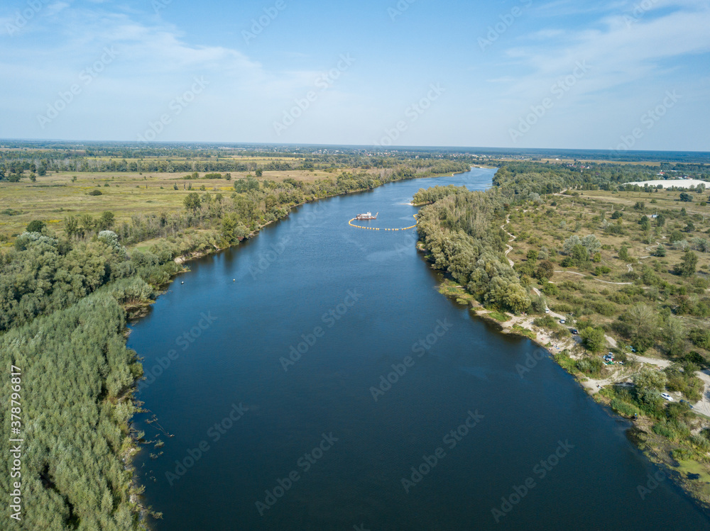 Aerial drone view. The bend of a wide river among green meadows. Sunny summer day. Aerial drone view. The bend of a wide river among green meadows. Sunny summer day.