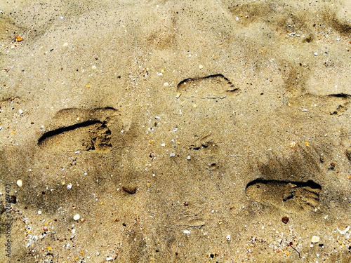 Empreinte de pieds sur le sable chaud de la plage