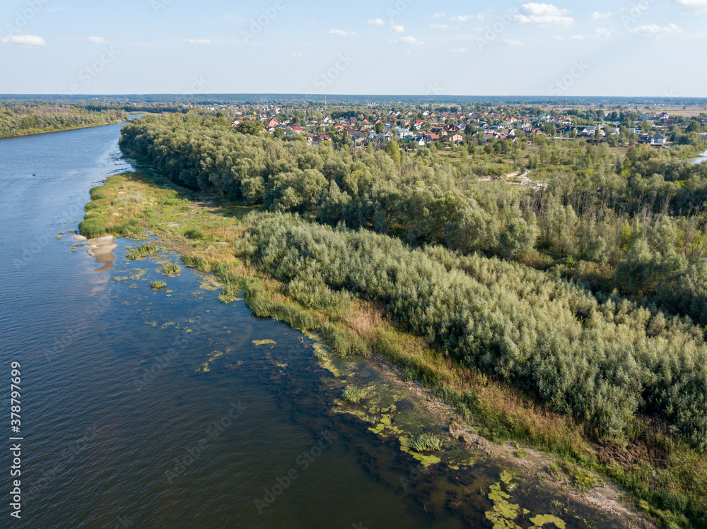 Green banks of a country river. Aerial drone view, sunny summer day.